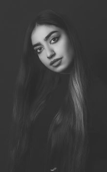 Graceful black and white portrait of a woman with long hair and captivating gaze.