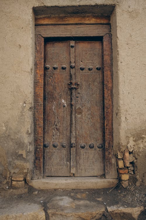 Brown Wooden Door on Brown Concrete Wall