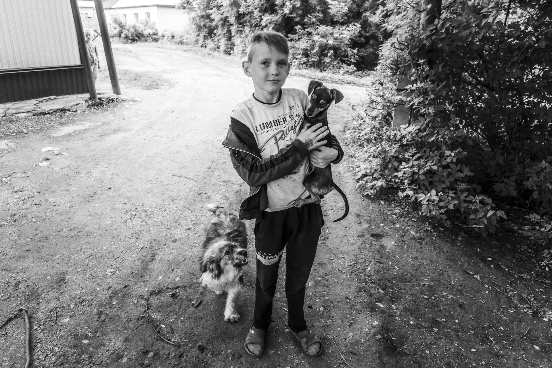 Young Boy Holding  Short Coated Small Dog