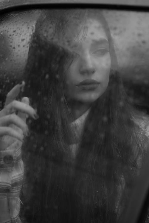 Free Grayscale Photography of Woman Behind Wet Glass Window Stock Photo