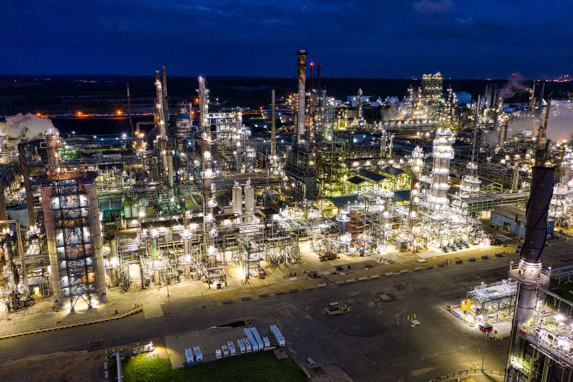 Planta industrial en operación durante la noche, montajes e ingeniería industrial