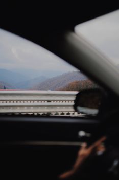 A scenic view of mountains visible through a car window, capturing the essence of a road trip.