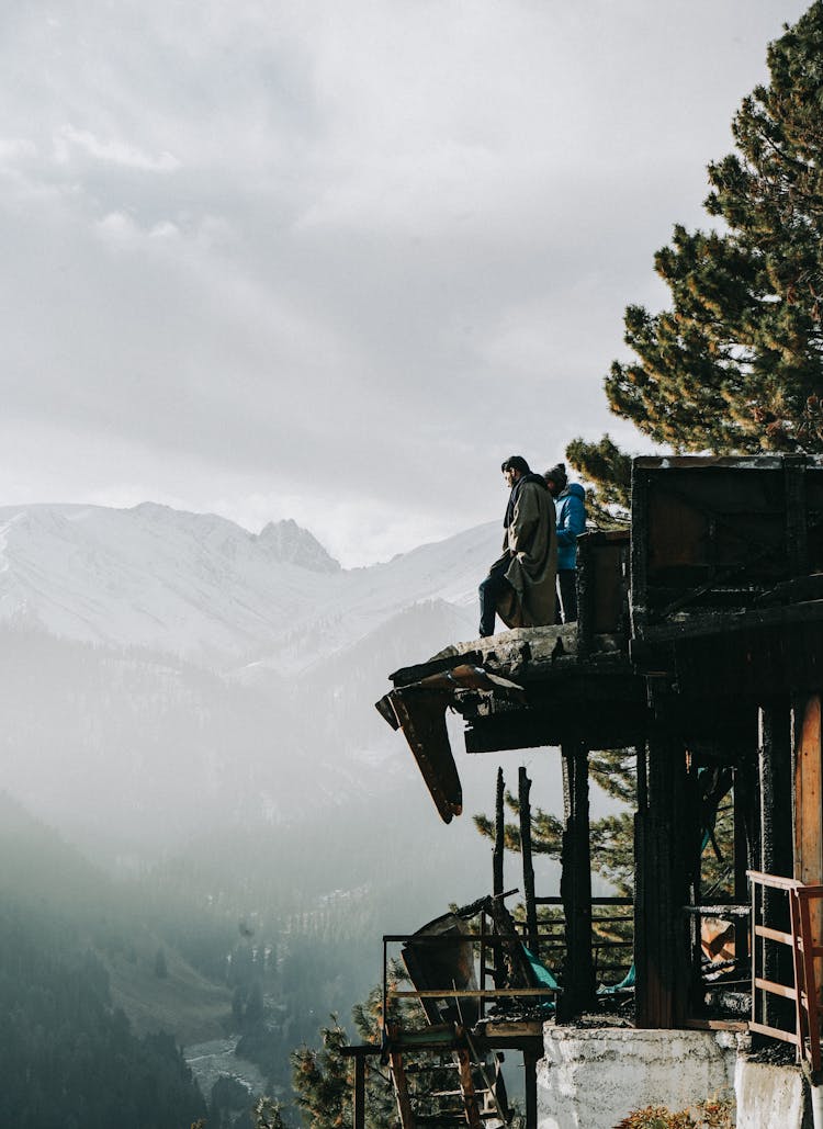 Men Standing On Broken Ledge Atop Moun