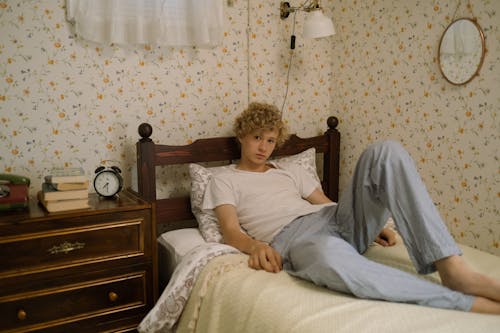 Free Blond Teenage Boy Lying on Bed Stock Photo