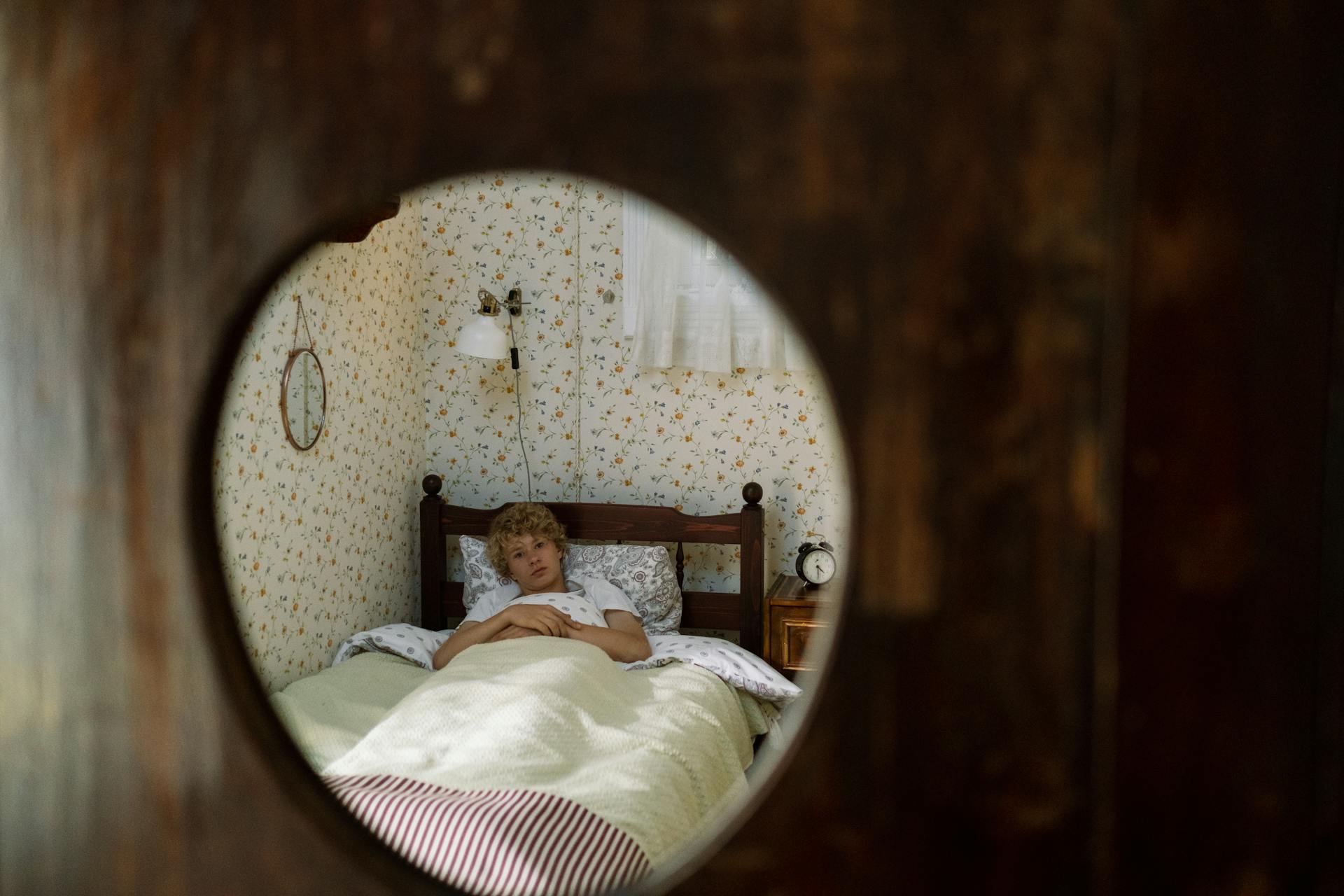 Blond Teenage Boy Lying in Bed in Mirror