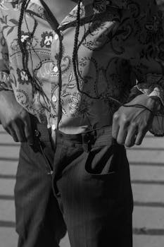 Elegant monochrome close-up of a person adjusting suspenders in Kharkiv, Ukraine.