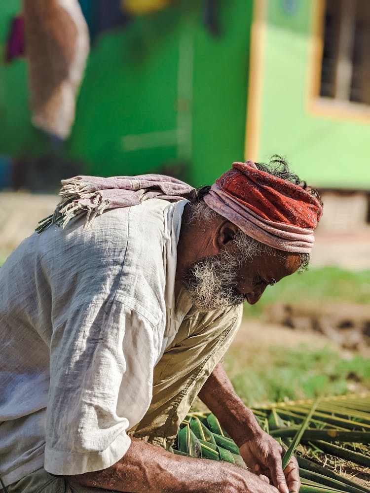 Elderly Man Weaving Mat From Bamboo