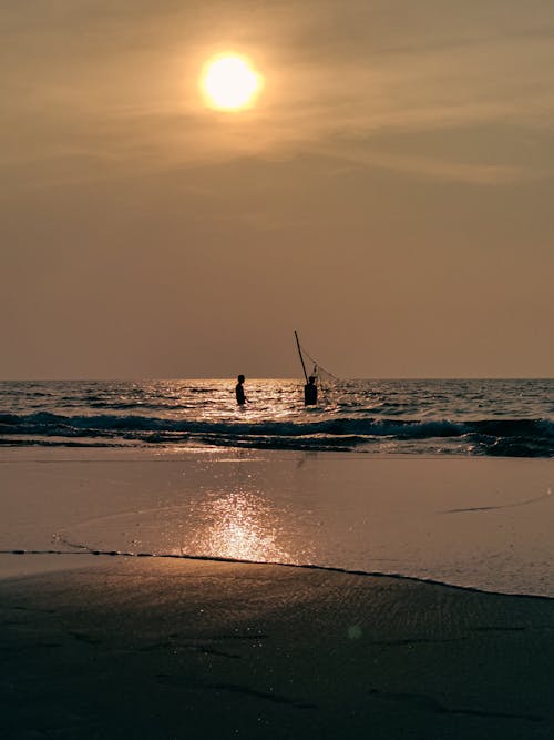 Free People on Sea during Sunset Stock Photo