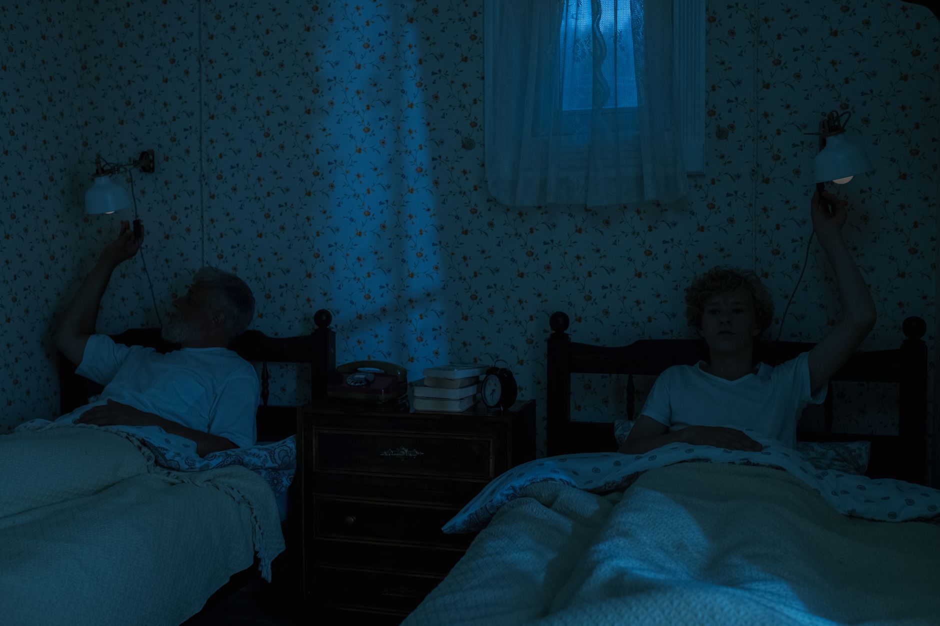 三個步驟,擺脫失眠找回安穩好眠 Two people in a cozy vintage bedroom turning off lamps for sleep