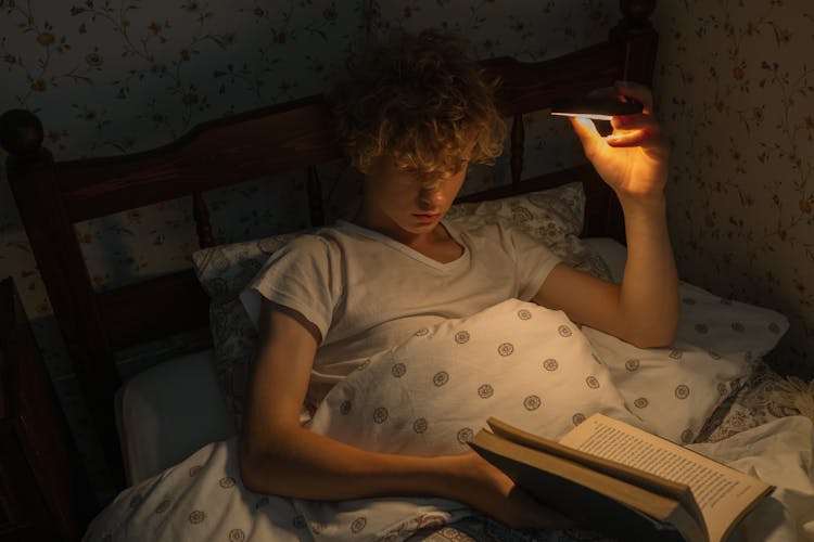 Teenager Reading In Bed At Night