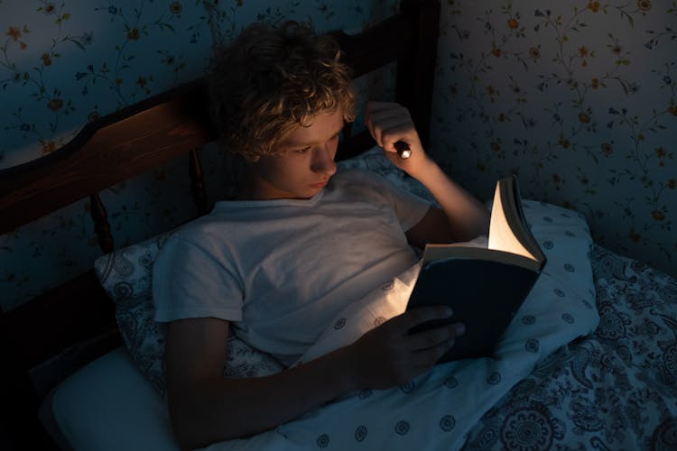 Teenager Reading In Bed At Night