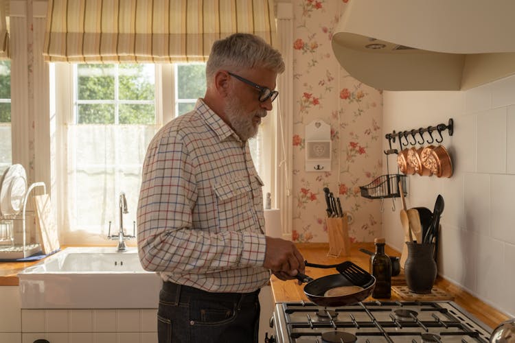 An Elderly Man Cooking A Pancake