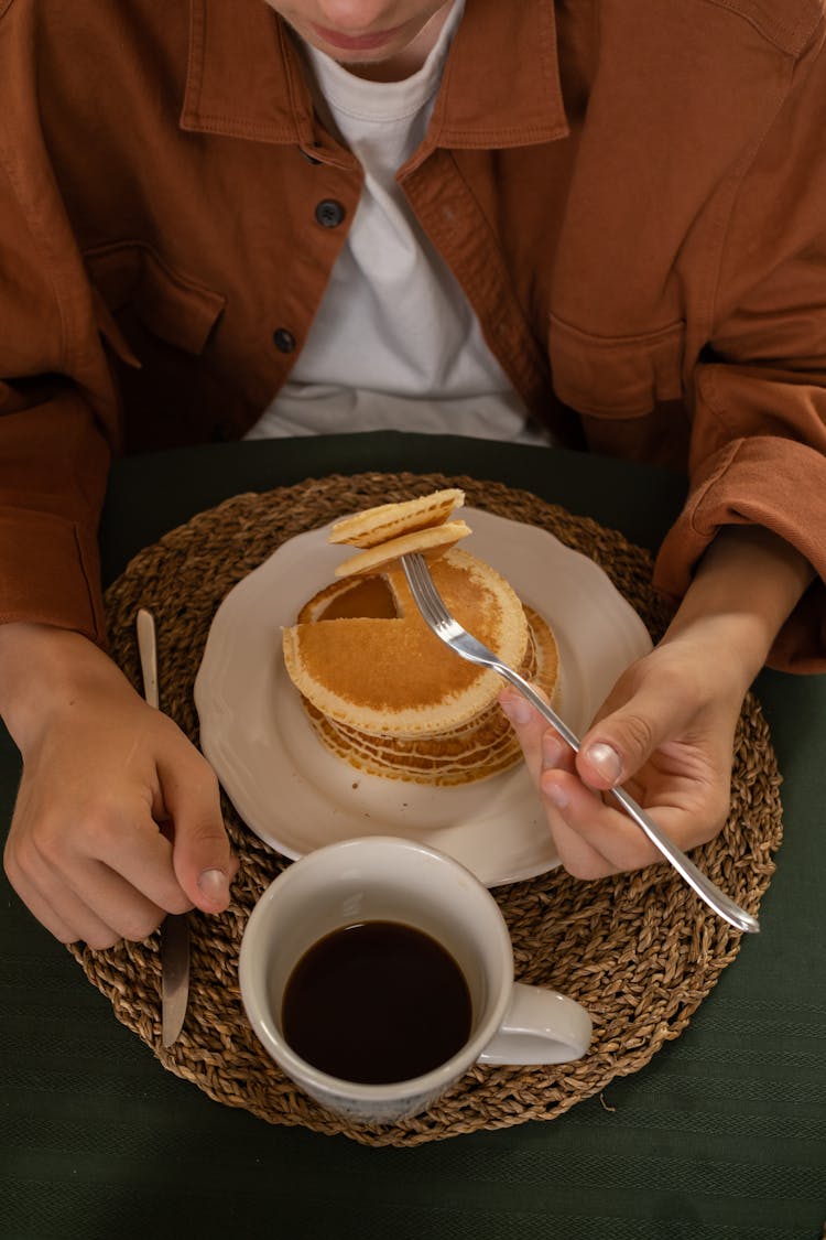 Man Eating Pancakes And Drinking Coffee