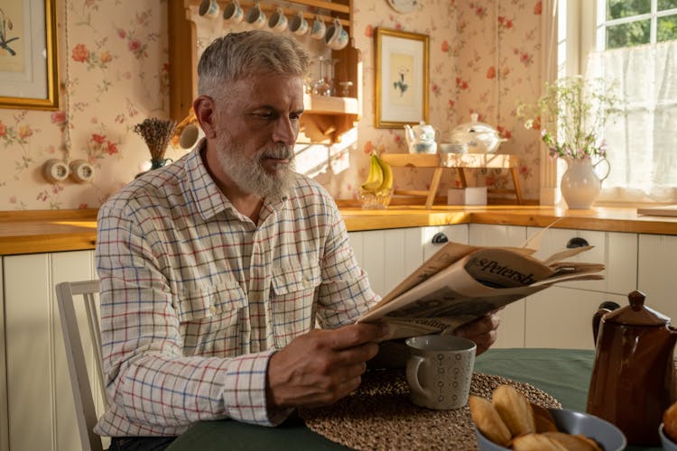 Elderly Man In Shirt Reading Newspaper