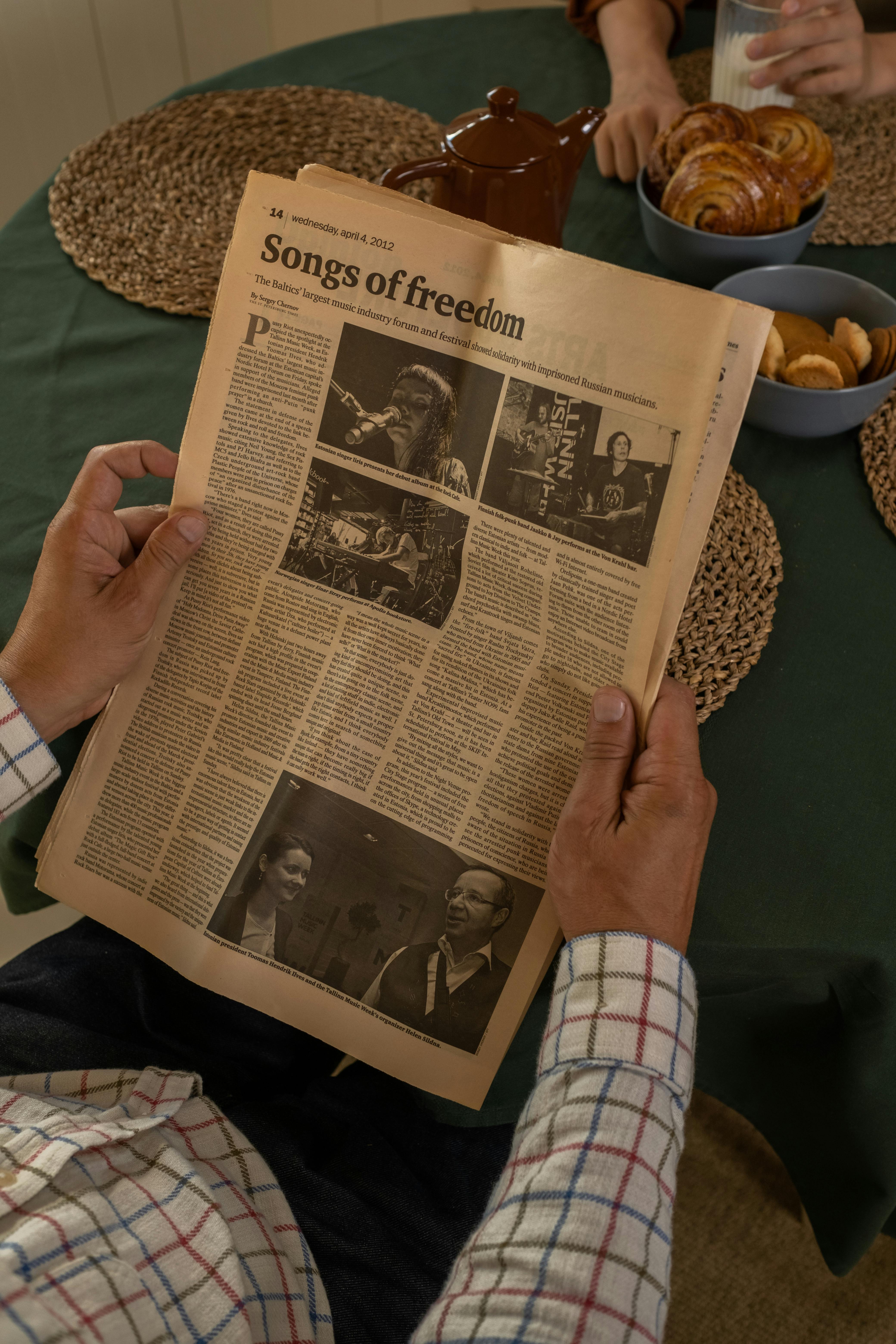 man in shirt reading newspaper