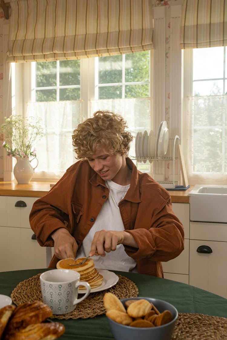 Teenage Boy Eating Pancakes For Breakfast