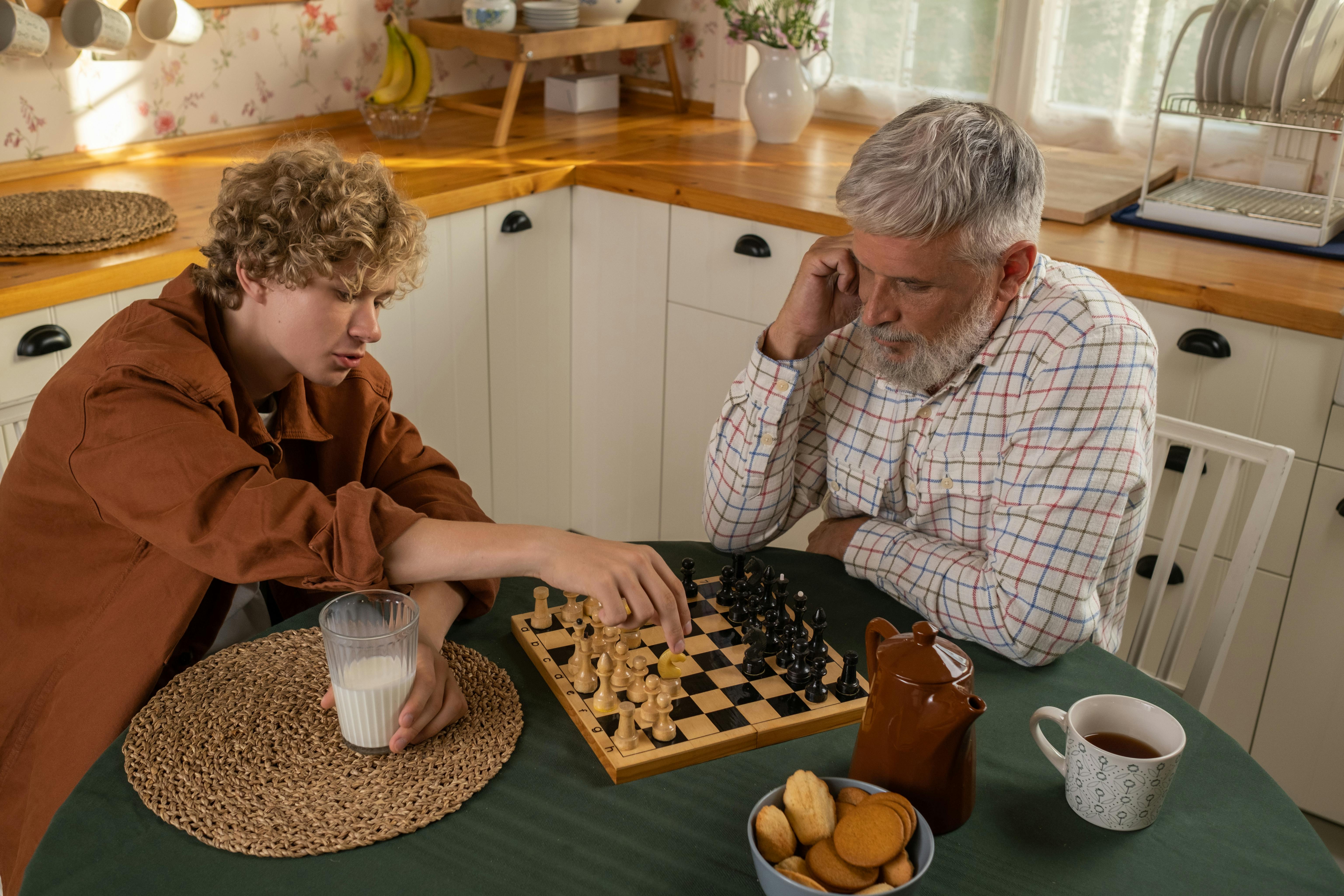 grandfather and grandson playing chess in kitchen