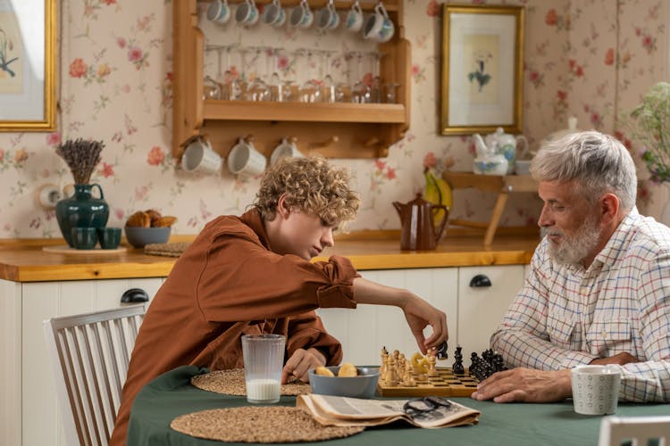 Teenager Playing Chess With His Grandfather