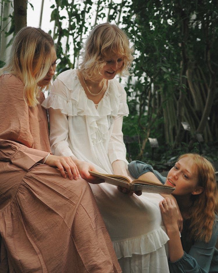 Women In Long Dresses Reading Book Together