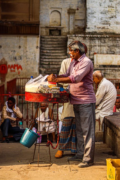 Free A vendor sells goods in a vibrant city market, capturing urban daily life and tradition. Stock Photo