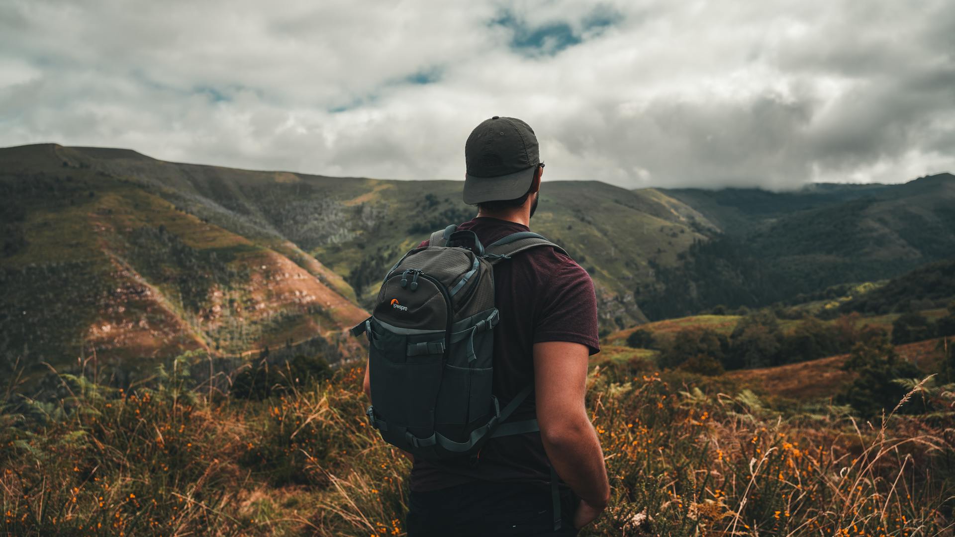 Man with backpack hiking in scenic Spanish mountains, perfect for adventure and travel themes.