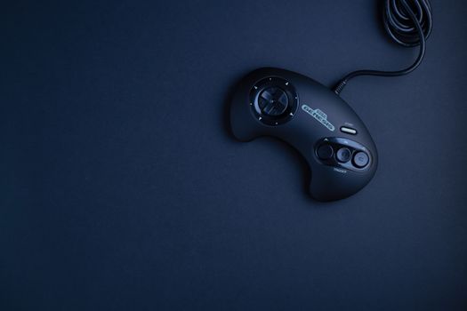 Navy blue vintage game console controller photographed from above on a dark background.