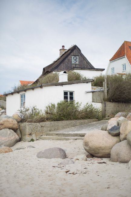Quaint seaside house with sandy surroundings and rocks in Denmark.