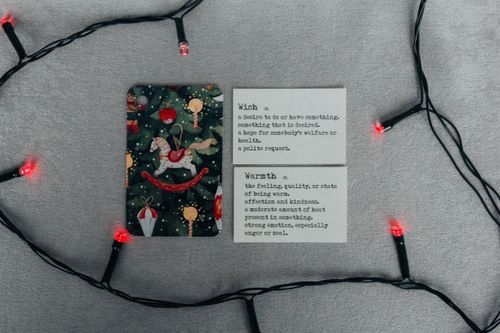 Free A holiday card and string lights with inspiring definitions set on a festive background. Stock Photo