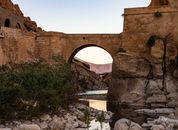 Brown Concrete Arch Bridge Under Blue Sky