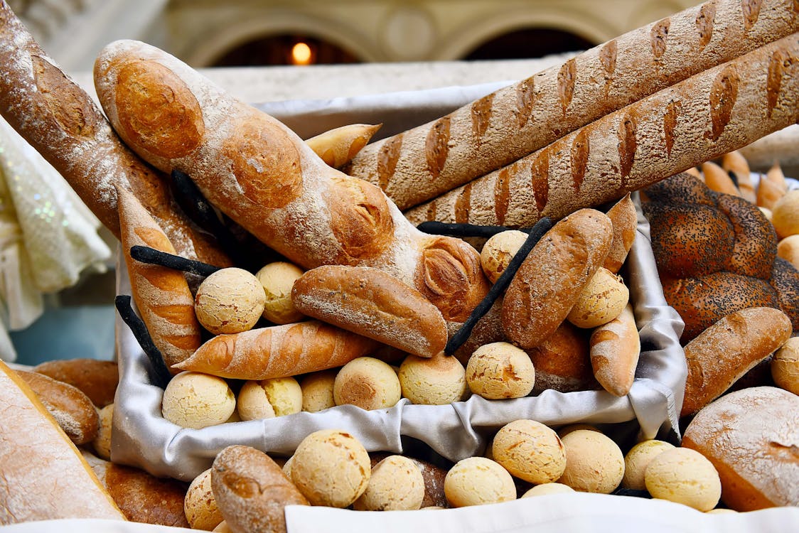 Variety of Breads on a Basket Covered in Cloth