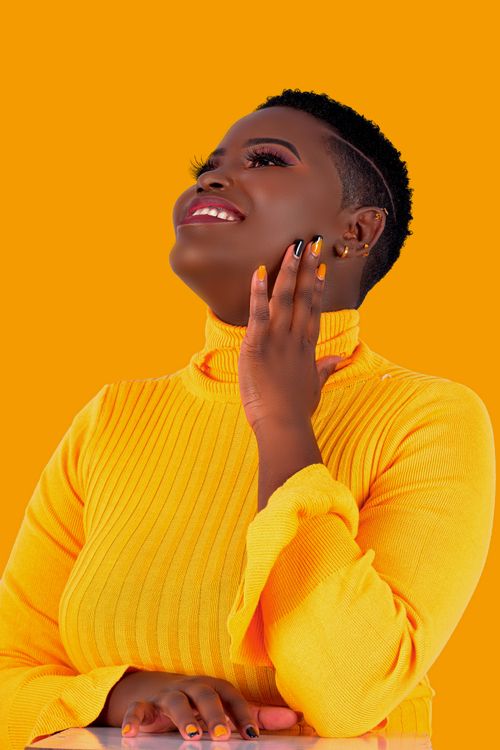 Free Stylish portrait of a woman with manicure wearing a bright yellow sweater. Stock Photo