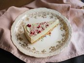 Cheesecake Triangle Sprinkled with Red Castor Sugar Laying on Ornamental Plate