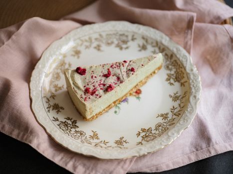 Cheesecake Triangle Sprinkled with Red Castor Sugar Laying on Ornamental Plate