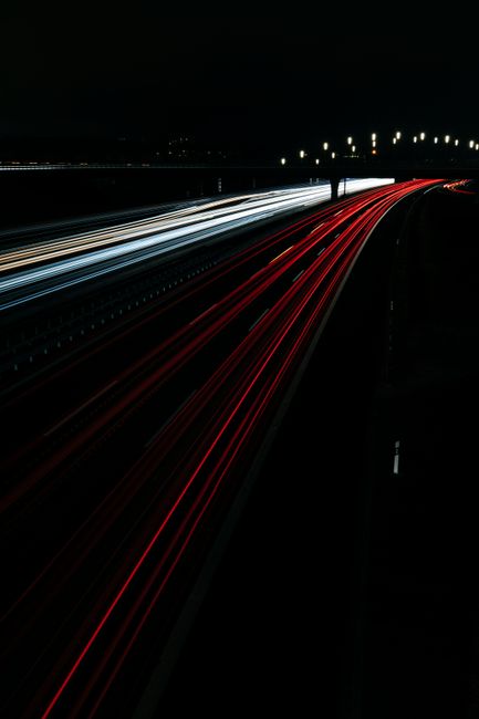 Vibrant long exposure capture of car lights on a freeway at night, creating dynamic light trails.