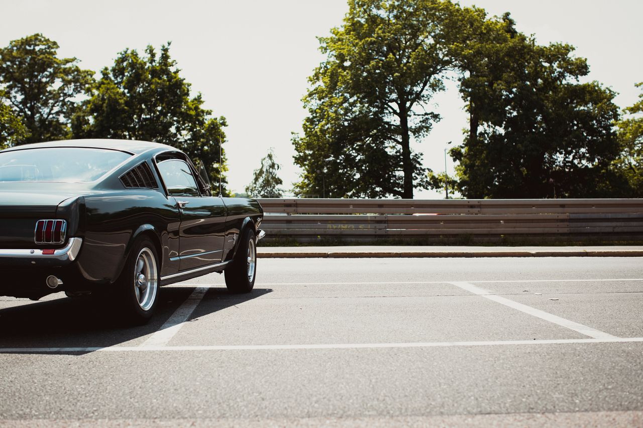 a vintage ford mustang parked in an outdoor lot on a sunny day iconic