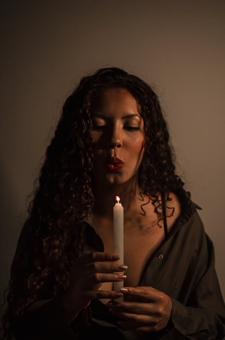 A Woman Blowing A Candle