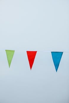 Bright and colorful bunting flags hanging against a plain background, perfect for celebratory themes.