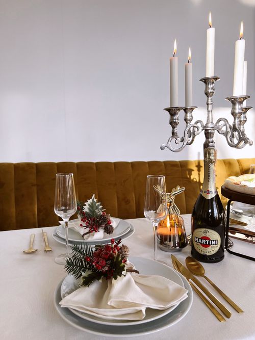 Free Sophisticated dinner setup featuring candles, gold cutlery, and festive decorations. Stock Photo