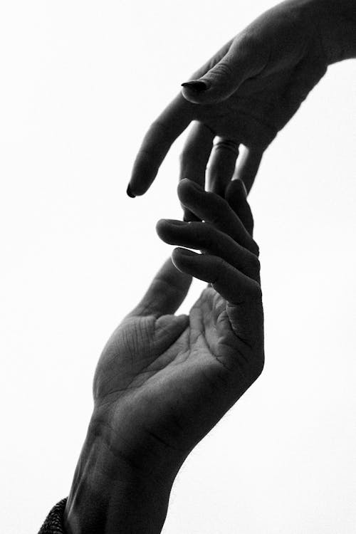 Free Grayscale Photo of Two People Touching Hands Stock Photo