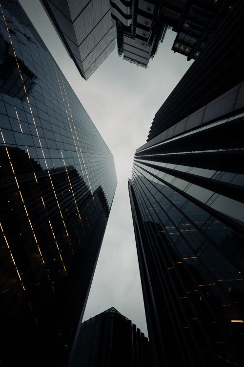 Free A low-angle view of modern skyscrapers creating a symmetrical pattern in London, UK. Stock Photo