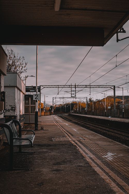 Free A deserted train station platform captured at sunset, emphasizing tranquility and solitude. Stock Photo