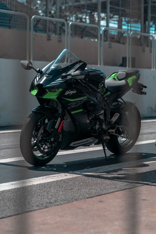 Free A powerful Kawasaki Ninja sports bike beautifully parked on a sunny race track. Stock Photo