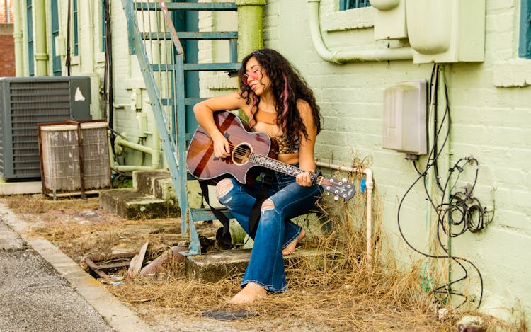 Woman Playing Guitar On Fire Stairs