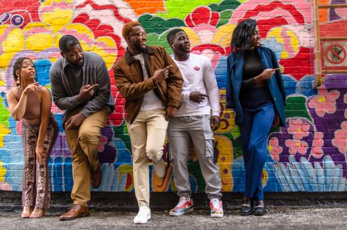 Free Group of diverse friends posing with playful expressions against a colorful mural in an urban setting. Stock Photo