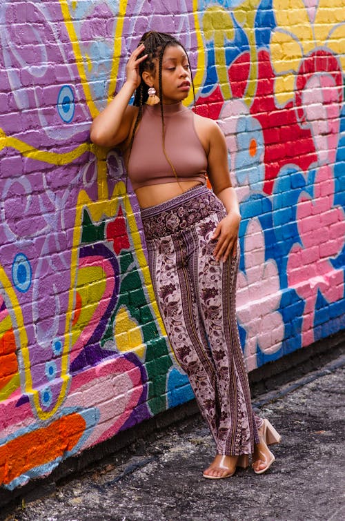 Free A Beautiful Woman Leaning on a Colorful Wall Stock Photo
