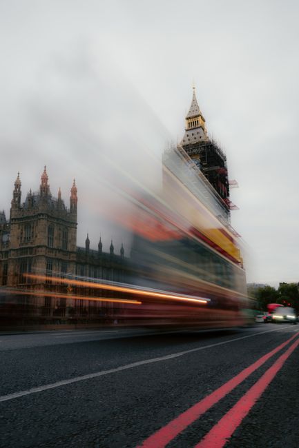 Blurred motion of a double-decker bus in front of Big Ben, showcasing dynamic London city life.