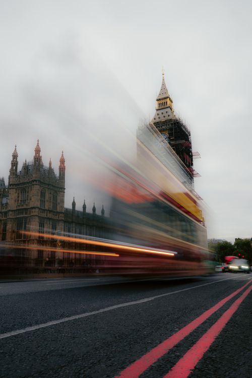 Free Blurred motion of a double-decker bus in front of Big Ben, showcasing dynamic London city life. Stock Photo