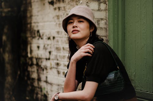 Photo of a Woman with a Brown Bag Wearing a Bucket Hat · Free Stock Photo