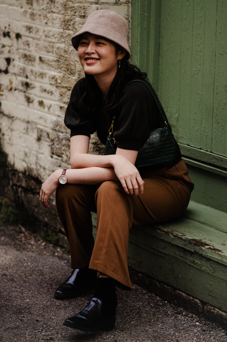 Portrait Of Smiling Woman Sitting On Doorstep