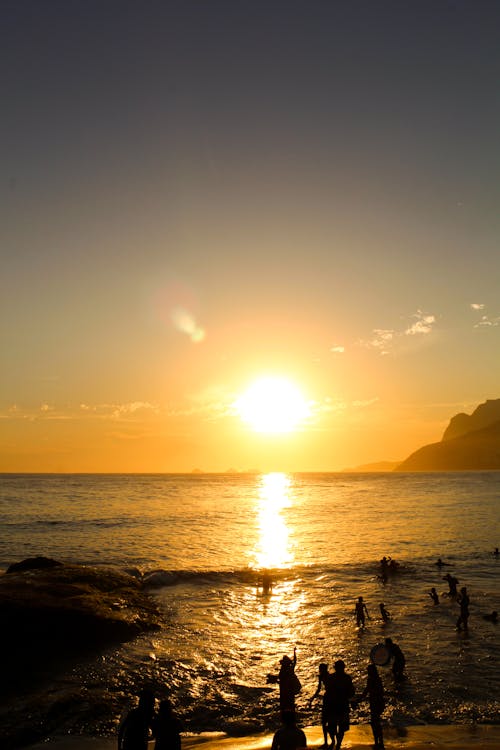 Free People on Beach during Sunset Stock Photo